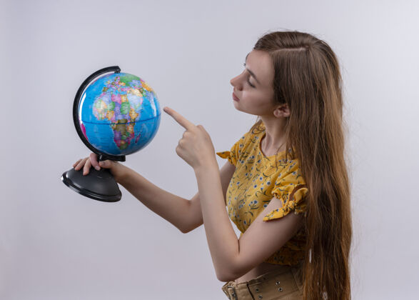 女人一个年轻女孩拿着地球仪 在孤零零的白墙上看着它女孩拿着年轻
