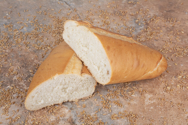 谷物半切小麦面包和大麦在大理石表面美味面包房新鲜