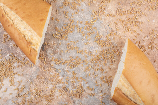 面包半切小麦面包和大麦在大理石表面美味一半谷物