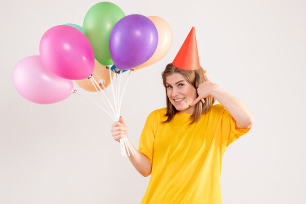 庆祝手持白色气球的年轻女子喜悦生日聚会