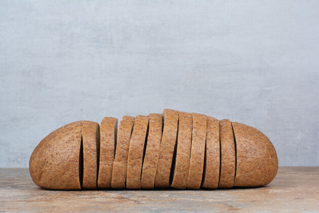 面包房在大理石桌上放几片黑麦面包新鲜切片面包