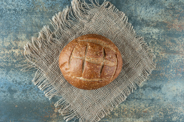 麻布一个全新的棕色面包放在麻布上面包美味美味