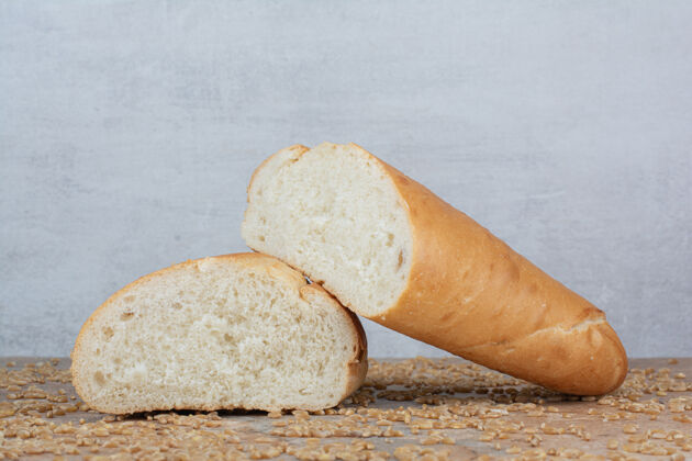 谷物大理石桌上放着半切的小麦面包和大麦面包食品新鲜