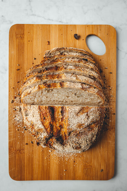 健康在木制砧板上垂直拍摄新鲜的酸面包小麦木板烹饪