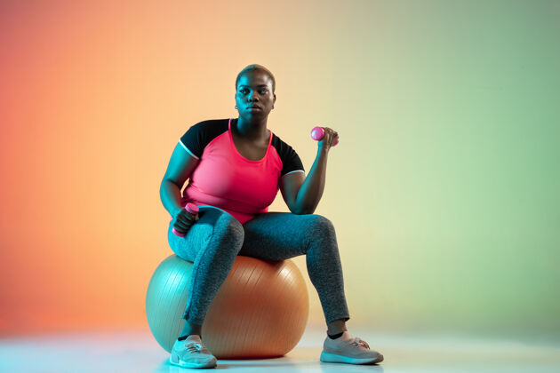 锻炼年轻的非洲裔美国加号女模特在斜坡墙上训练非洲健身健身房