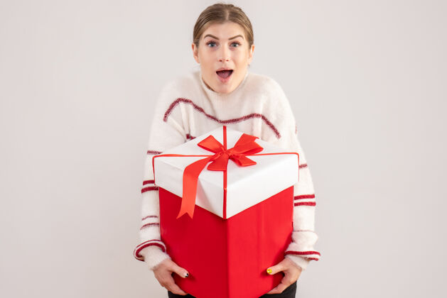 年轻的女性年轻的女性拿着礼物在白色的盒子里盒子圣诞节情绪