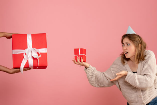 购物者年轻的女性拿着圣诞礼物 接受粉色的男性礼物粉红色礼物年轻的女性