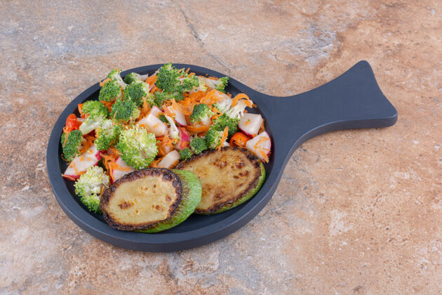 胡萝卜平底锅配炸西葫芦片和大理石表面的混合蔬菜沙拉蔬菜健康营养