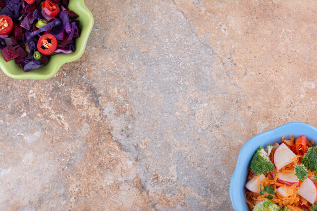 红卷心菜相反排列的不同沙拉碗展示在大理石表面西兰花蔬菜混合物