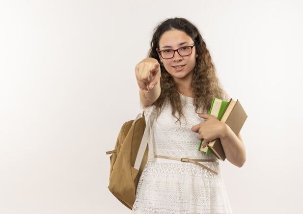 信心自信的年轻漂亮的女学生戴着眼镜 背着书包拿着书 指着白色的空白处背眼镜漂亮