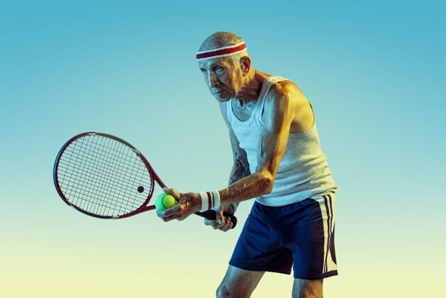 姿势穿运动服的老人在斜坡上打网球老年人健康男性