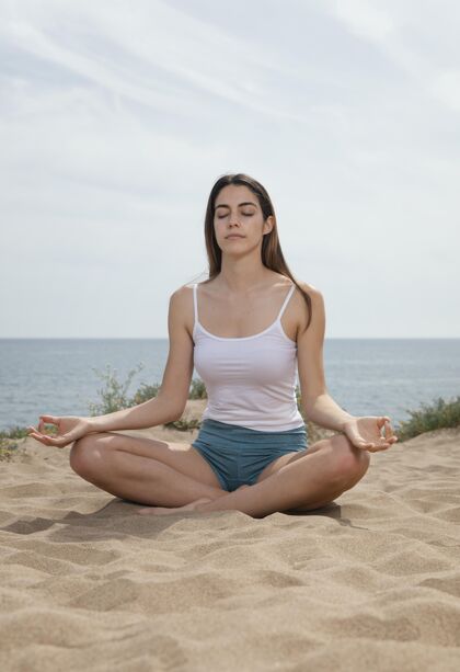 身体在沙滩上打坐的年轻女子身体平衡健活方式