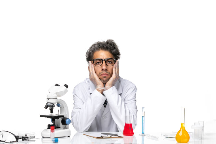 桌子正面图穿着特殊白色西装的中年科学家围坐在桌子旁 拿着解决方案科学视图医学