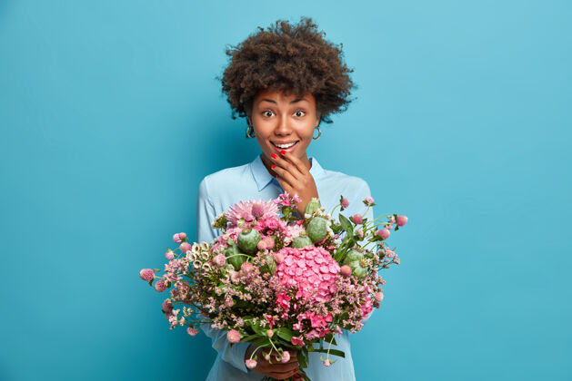 快乐积极的非裔美国妇女持有不同的鲜花美丽的花束姿势人花
