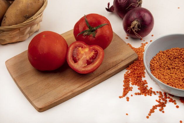 扁豆顶视图橙色小扁豆放在碗里 西红柿放在木制的厨房板上 红洋葱被隔离在白色的墙上番茄木头洋葱