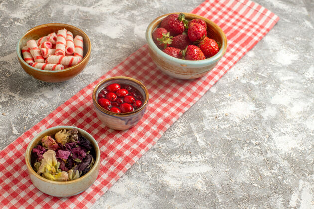 糖果前视图糖果和果冻与草莓在白色表面糖果甜花新鲜鲜花饮食