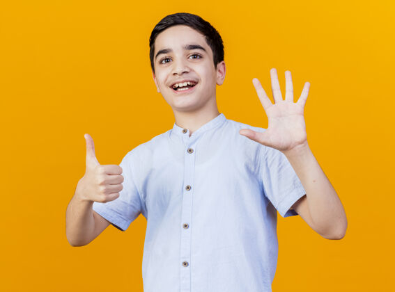 手快乐的年轻白人男孩展示了六只手 看着孤立在橙色背景上的相机六岁男孩快乐