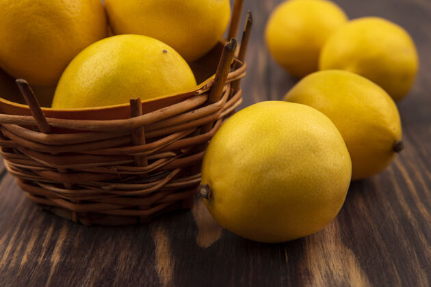 食品近距离观看柠檬桶上的酸味柠檬 柠檬被隔离在木墙上水果块视野