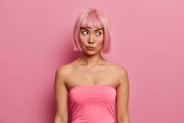 粉色头发一张严重不满的女人的照片 梳着鲍勃的发型 穿着粉色上衣 沉思着 认真地思考着提议 想办法如何解决麻烦 思考决定女性人姿势