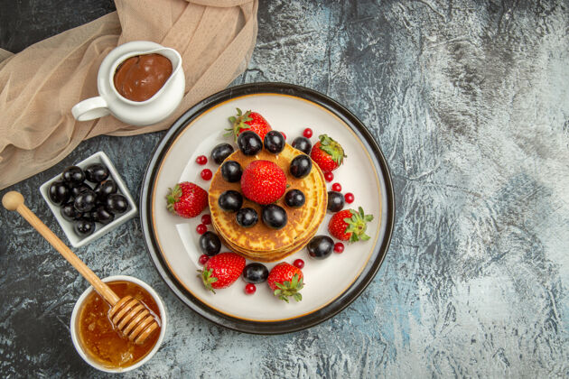 甜点俯瞰美味的薄饼与蜂蜜和水果在光表面甜水果蛋糕营养早餐水果