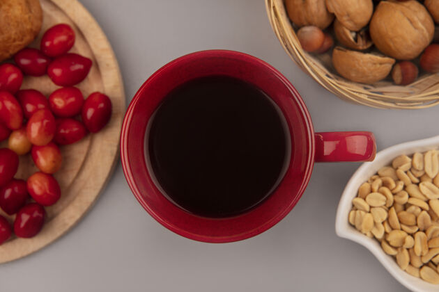 杯子一杯红咖啡的俯视图 上面放着一块木制的厨房板 桶上放着坚果 桶上放着一堵灰色的墙厨房风景餐厅