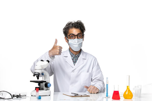 实验室前视图穿着特殊套装的中年科学家坐着摆姿势前面化学坐