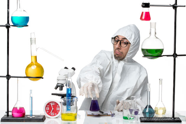 实验室正面图穿着特殊防护服的男科学家拿着装有紫色溶液的烧瓶持有专业医学