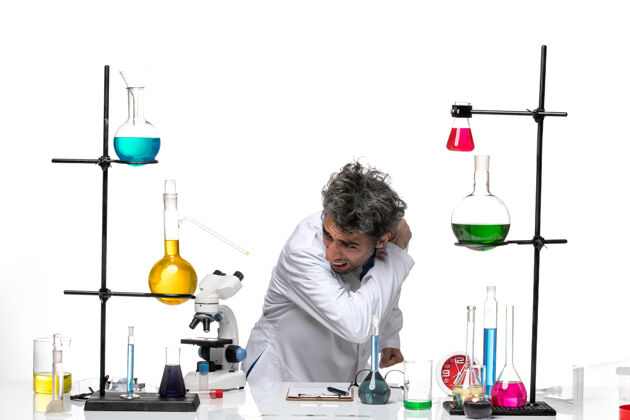 罐子前视图穿着白色医疗服的男科学家在桌子前拿着解决方案病毒人科学