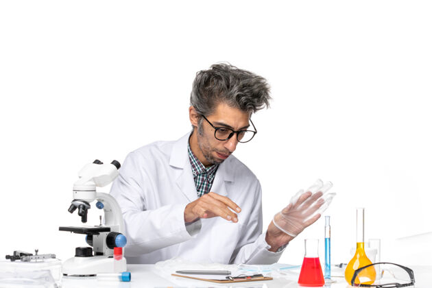 外套正面图身着特殊套装的中年科学家围坐在桌子旁 拿着解决方案实验室观察实验室