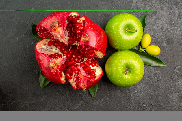水果顶视新鲜石榴与青苹果在黑暗的表面成熟的水果颜色观赏多汁顶级