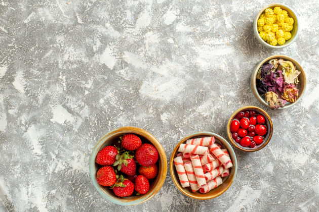 浆果顶视图新鲜的红色草莓和糖果 表面呈白色 果味甜美 糖果色甜点草莓水果