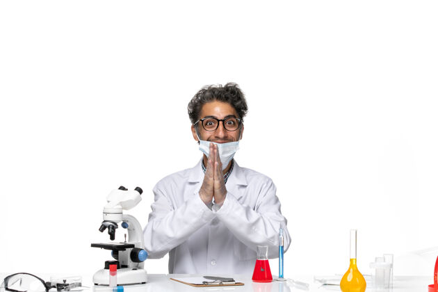 前面正面图身着特殊套装的中年科学家围坐在桌子旁 拿着解决方案科学解决方案化学