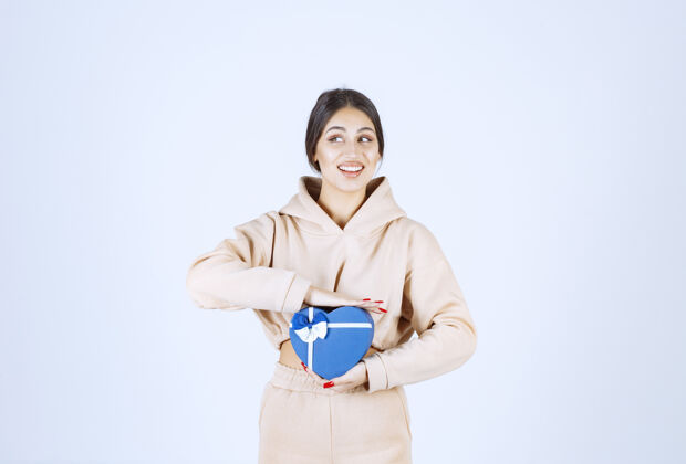 周年纪念年轻女子拿着一个蓝色心形礼盒 看起来很开心年轻人类乐趣