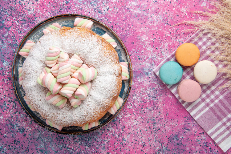 糖粉红面上有法式马卡龙的糖粉蛋糕俯视图法国美味饼干