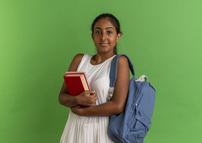 笔记本高兴的小女生背着书包抱着书 把笔记本孤立在绿色上包拥抱表情
