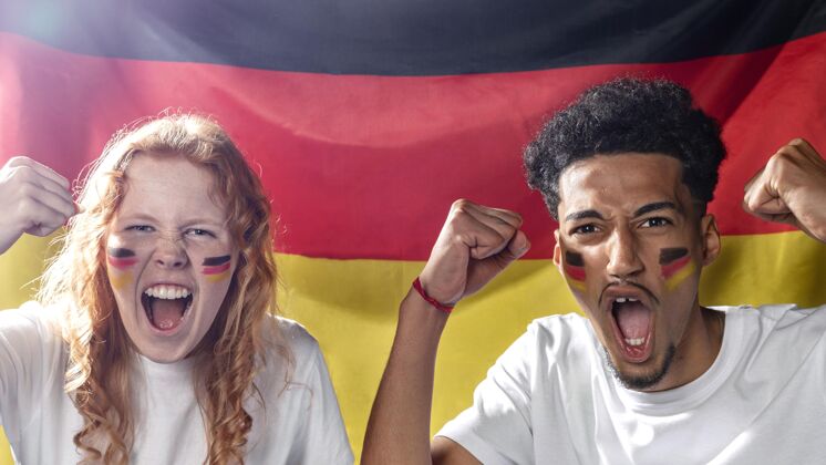 男子手持德国国旗的欢呼男女的正面图人足球比赛公民