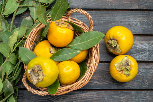 健康顶视图新鲜柿子放在木桌上的篮子里 水果醇香熟透成熟新鲜柿子木头