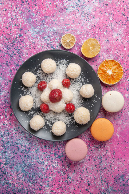 糖果俯瞰美味的椰子糖甜球与马卡龙在粉红色的表面食物美味麦卡龙