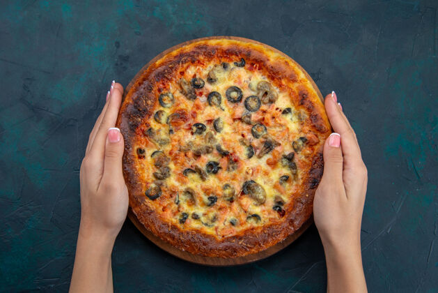 午餐深蓝色桌子上美味的橄榄和奶酪比萨饼的俯视图面团含糖奶酪