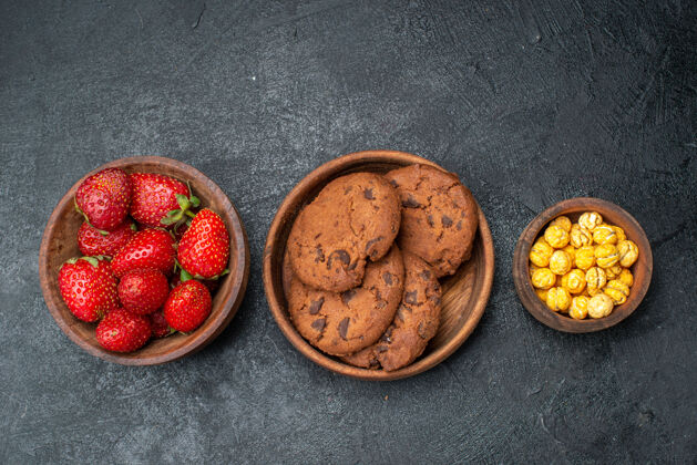 核桃顶视图新鲜草莓配饼干放在深色桌子上甜甜的水果饼干甜点深色饼干