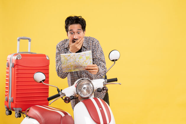 年轻男子正面图：年轻男子骑着自行车在黄色的地图上观察着震惊的表情假期速度人