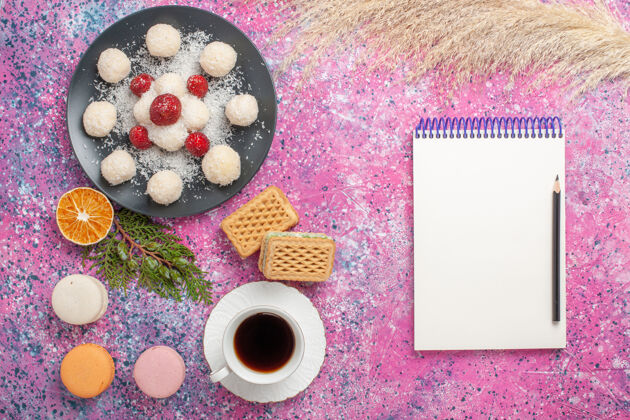 糖果美味的椰子糖与新鲜草莓和华夫饼在粉红色表面俯瞰食物椰子美味