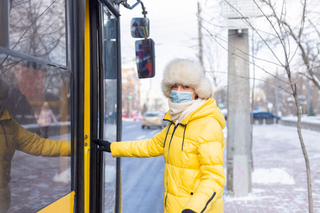 车站一个微笑的年轻女人在冬天走进公共汽车坐着漂亮等待