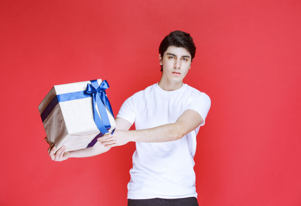 紧身衣一个男人双手拿着一个包着蓝丝带的白色礼盒积极意外快乐