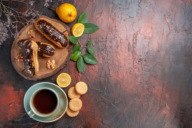 顶俯瞰美味的巧克力和一杯茶在深色的餐桌上甜点甜蛋糕背景橘子健康