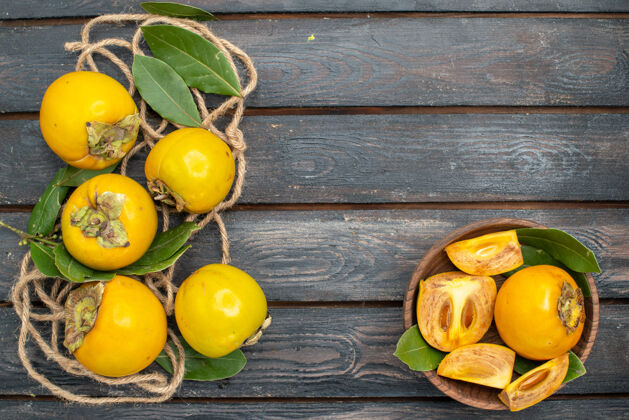 黄色顶视图木桌上新鲜甜甜的柿子 成熟水果的味道多汁成熟健康