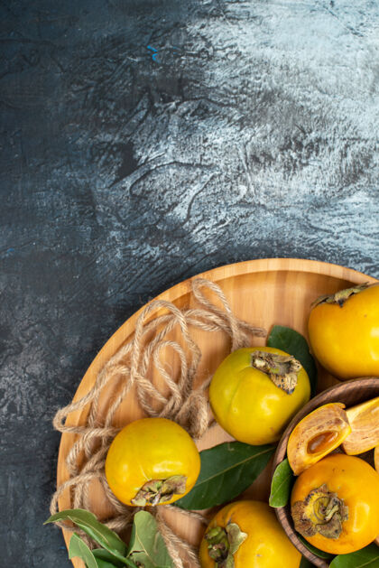 食物顶视图新鲜甜甜的柿子放在深色的桌子上成熟的水果成熟复制空间水果