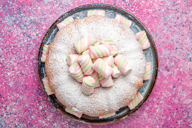 可口粉红色表面有棉花糖的糖粉蛋糕俯视图饼干棉花糖面团
