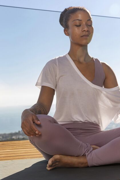 垂直坐在瑜伽垫上冥想的女人运动训练生活方式