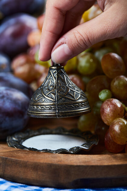 紫罗兰新鲜的李子 一串葡萄和盐放在木板上美味自然浆果